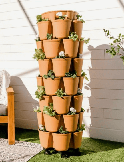 rain barrel surrounded by stacked up planters